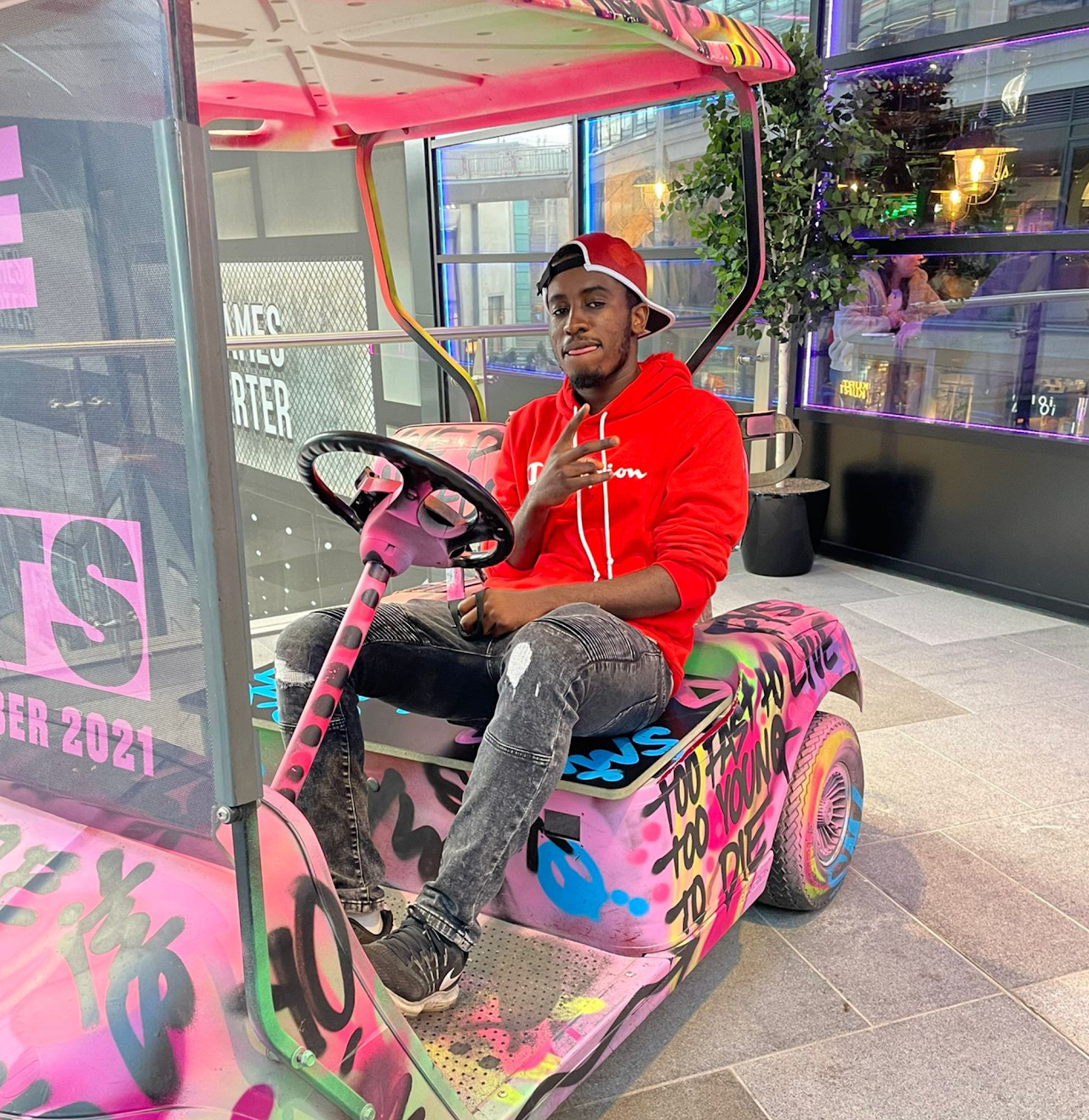 Lewin Leon seated in a colourful urban art installation